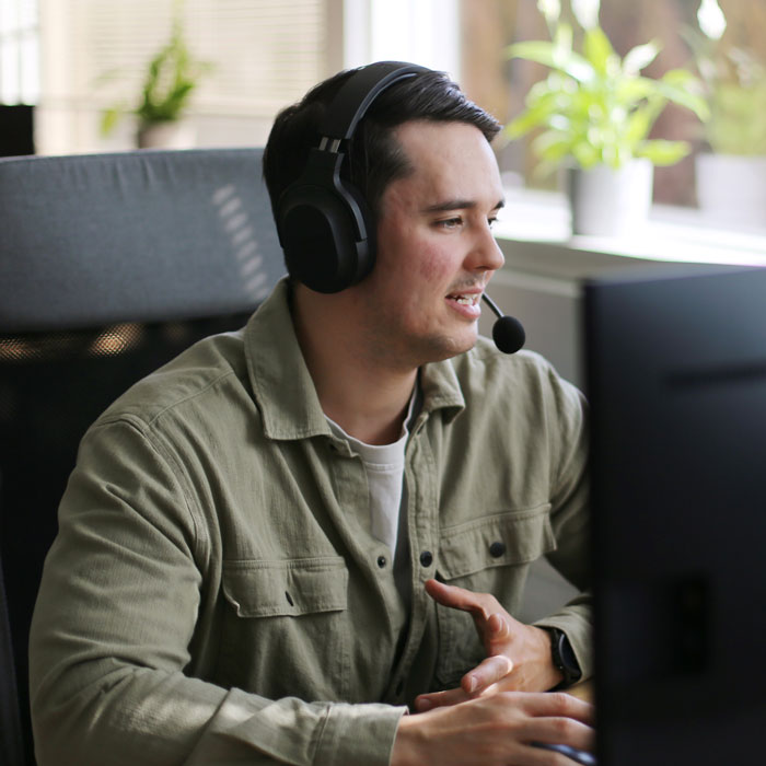 Medarbejder med headset der giver hjælp til CleanManager, med personlig support til rengøringsvirksomheder.